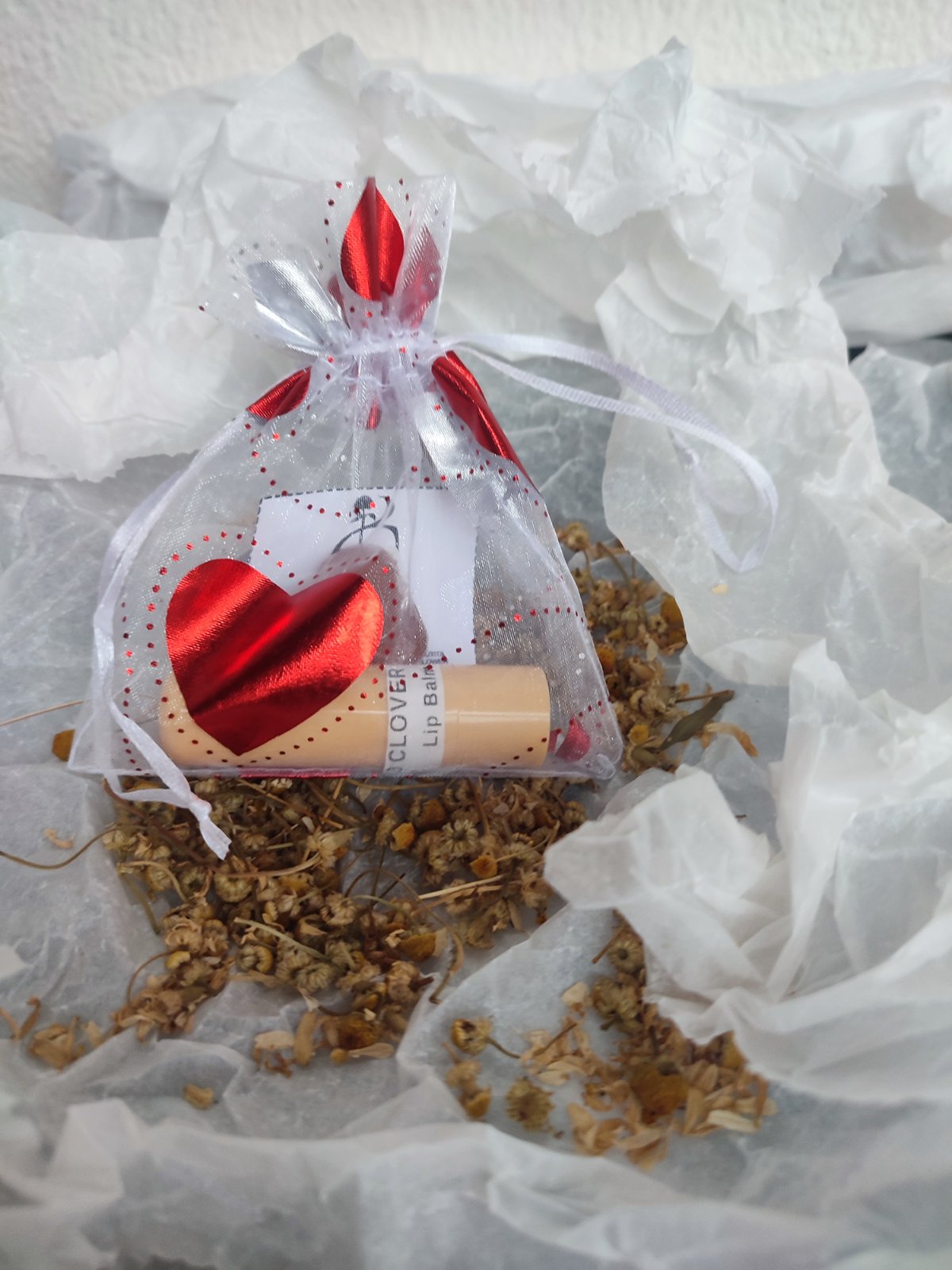 Single beeswax lip balm in a white organza bag with a red heart, ideal for party favors or small gifts